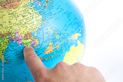 A Finger pointing to Thailand in a World Globe