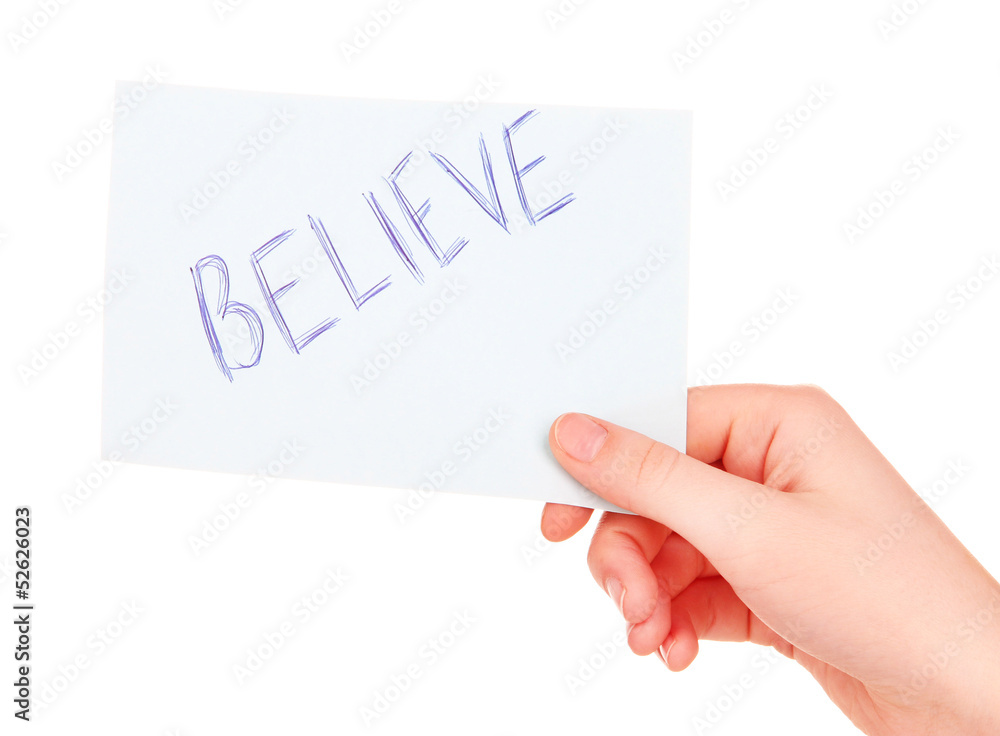 Believe word on piece paper in hand isolated on white Believe word on piece paper in hand isolated on white