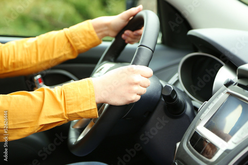 Female hands over a wheel in the car, close up