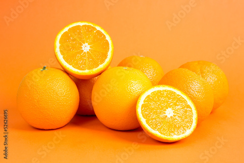 Juicy oranges in front of orange background