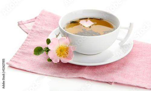 Cup of herbal tea with hip rose flowers, isolated on white