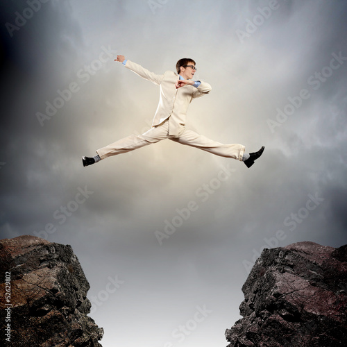 Businessman jumping over gap © Sergey Nivens