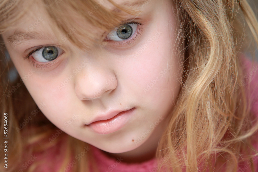 Closeup portrait of little blond Caucasian girl in pink