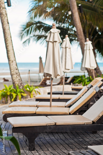 Beach chairs near swimming pool in tropical resort, Thailand. © Anastasiia Krivenok