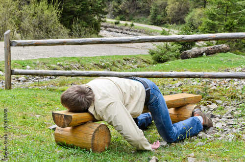 Young blond man deeply sleeping on a bench outdoor