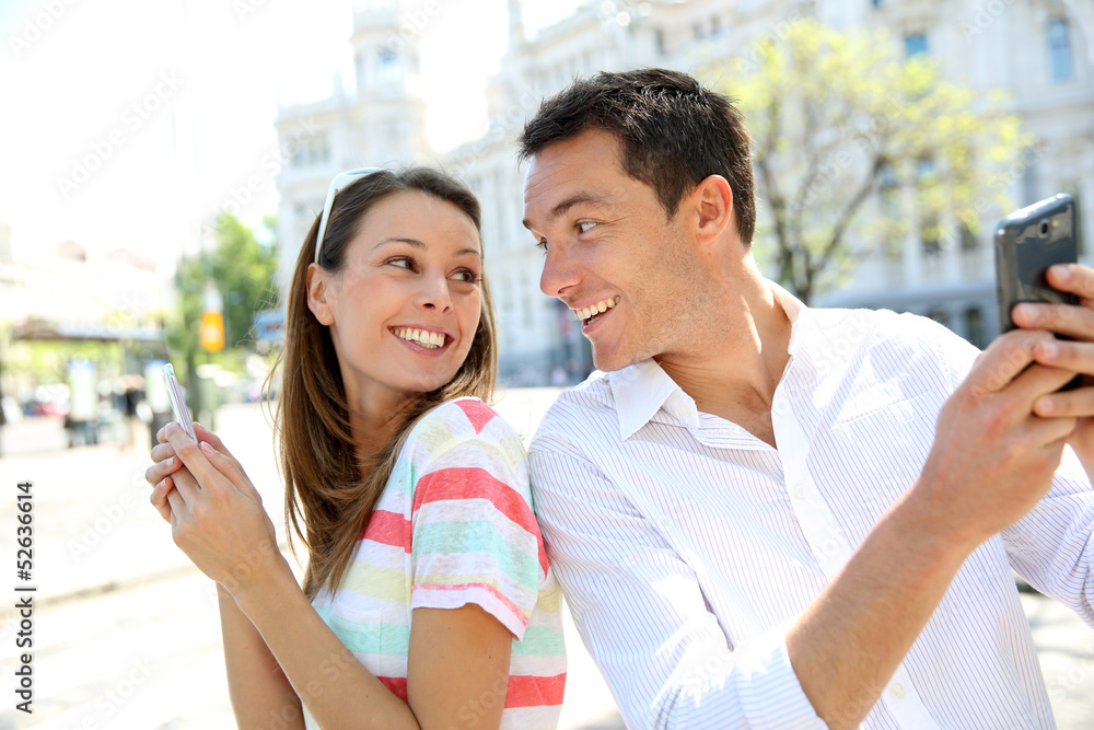 Couple of tourists in Madrid using smartphone