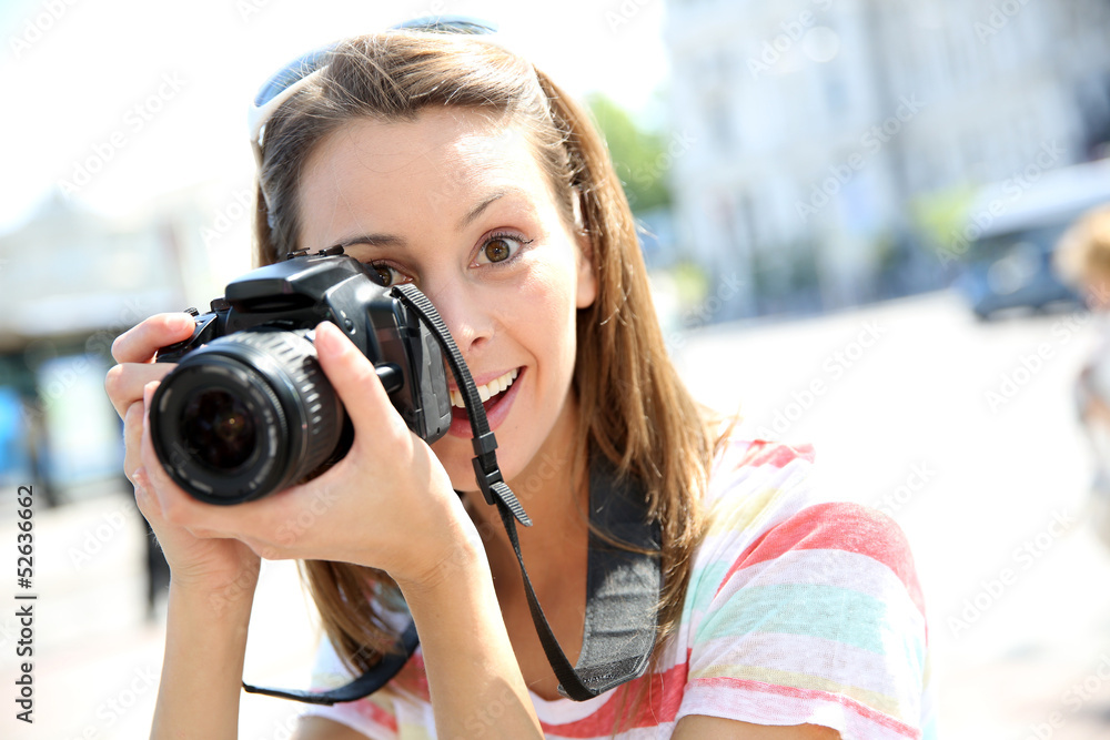 Portrait of young woman holding reflex camera