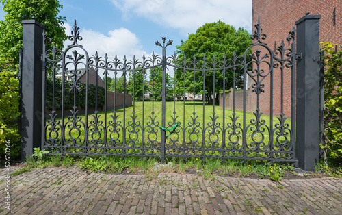 Ornate wrought iron gate with a chain and padlock.