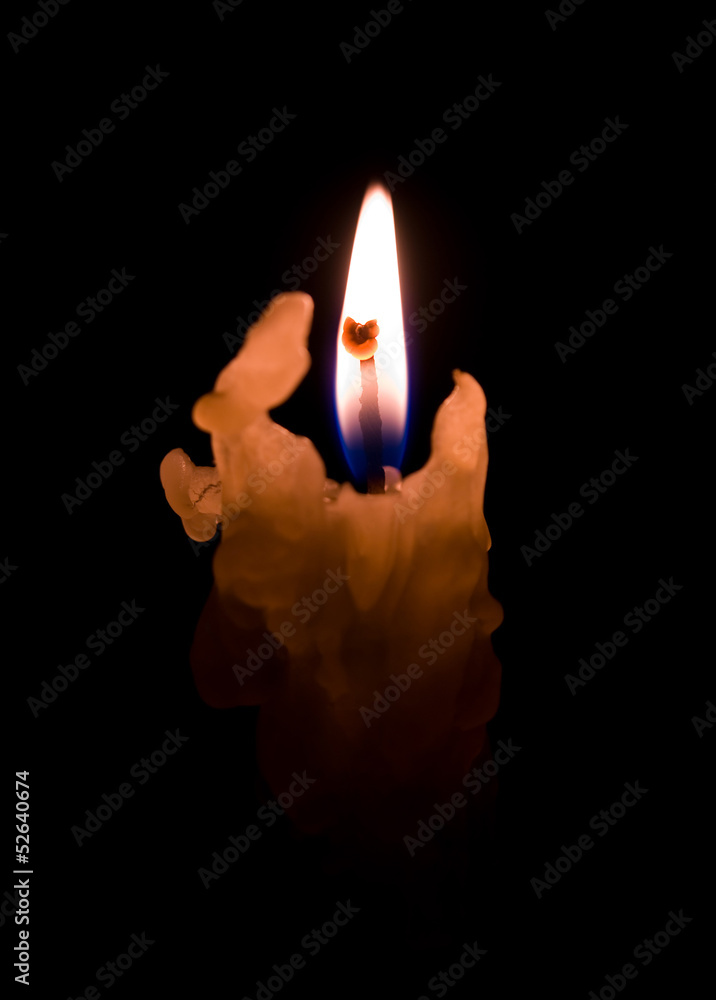 Fototapeta premium One candle flame at night closeup - isolated
