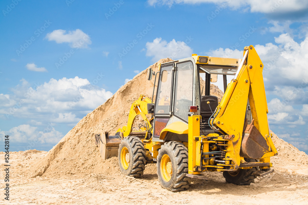 Tractor on the sand with blue sky background