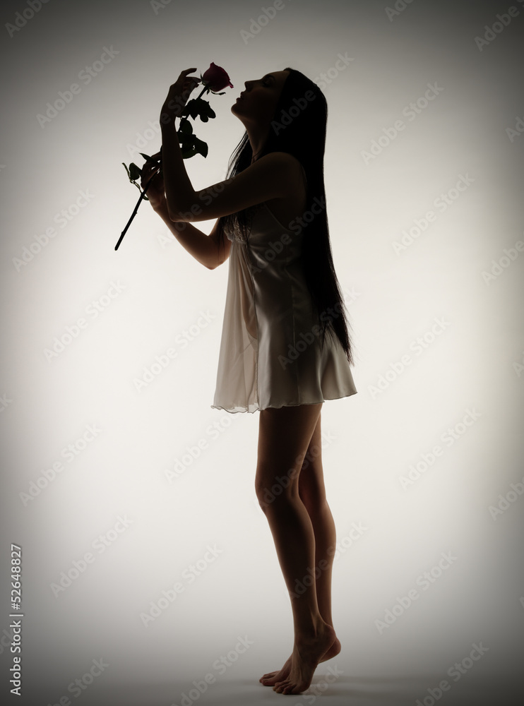 Silhouette of young girl with rose flower