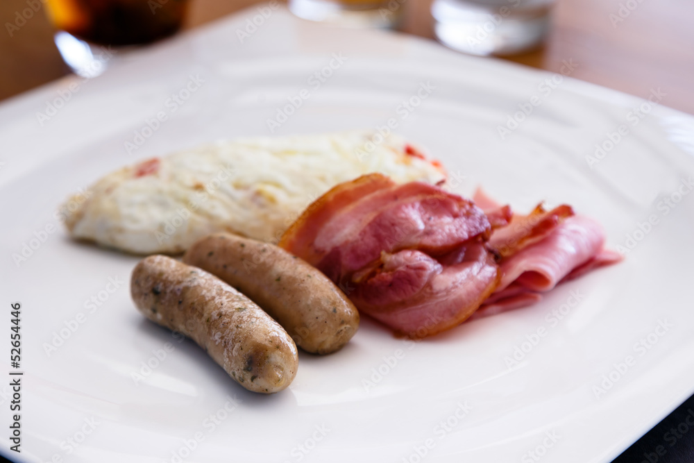 Breakfast dish include white egg omellete bacon and sausage Breakfast dish include white egg omellete bacon and sausage