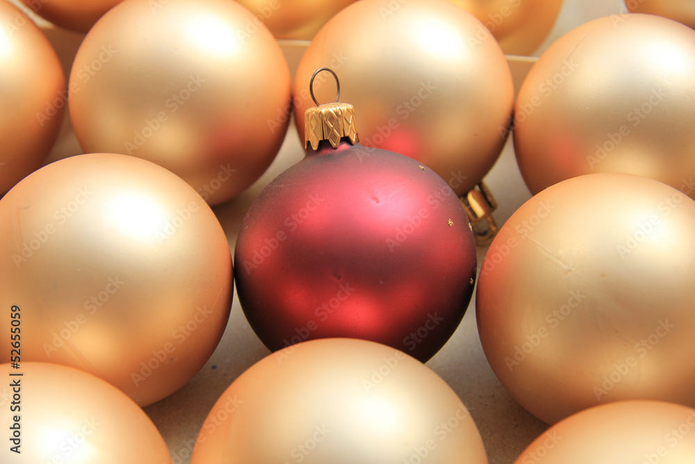 Red ornament on a pile of golden ornaments Red ornament on a pile of golden ornaments