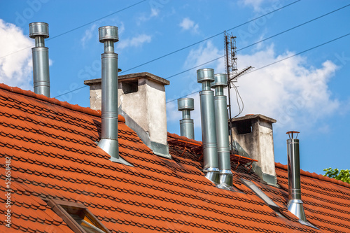 Chimneys on a building rooftop against a blue sky.