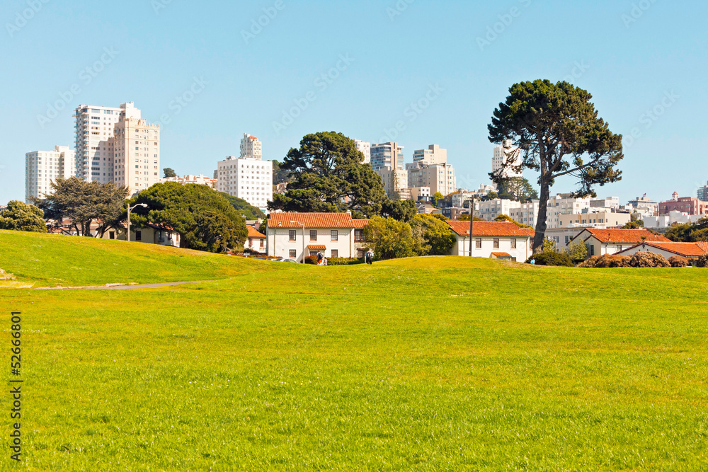 Green park with white skyscraper skyline in San Francisco. Blue