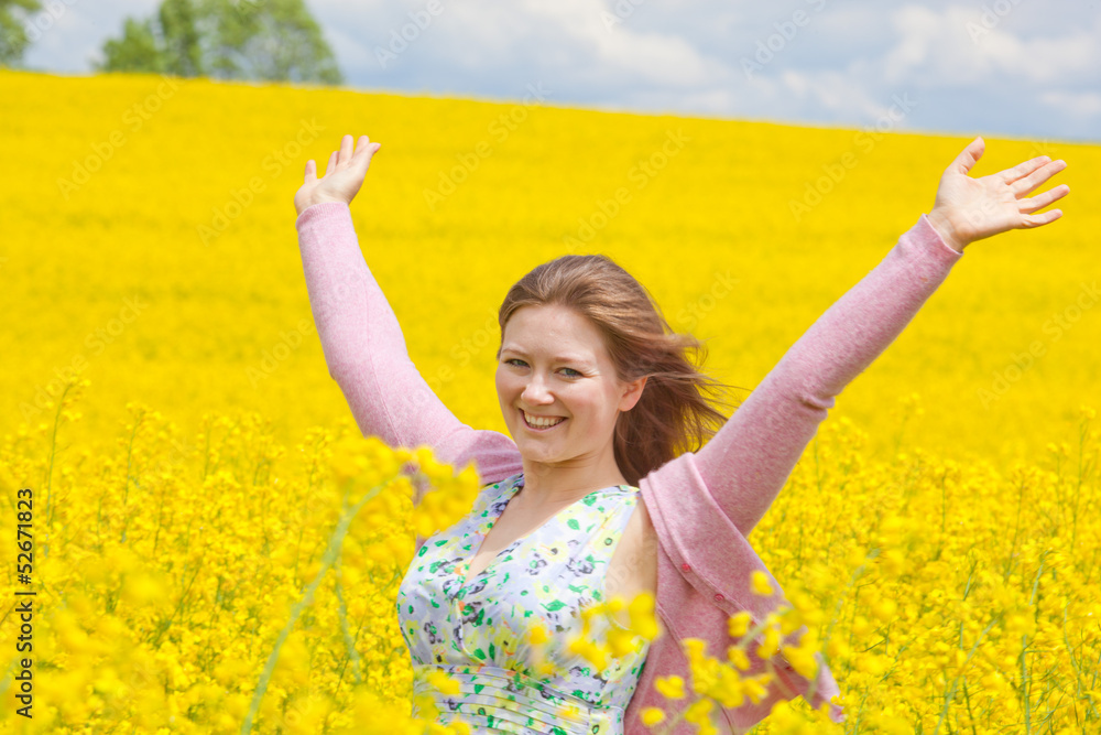 Naklejka premium lachende frau im raps feld