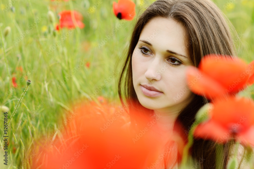 Naklejka premium pensive girl in poppies field