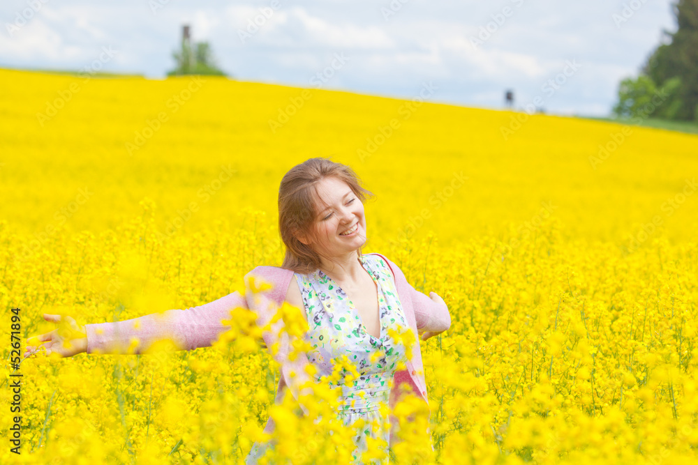 Fototapeta premium lachende frau im raps feld