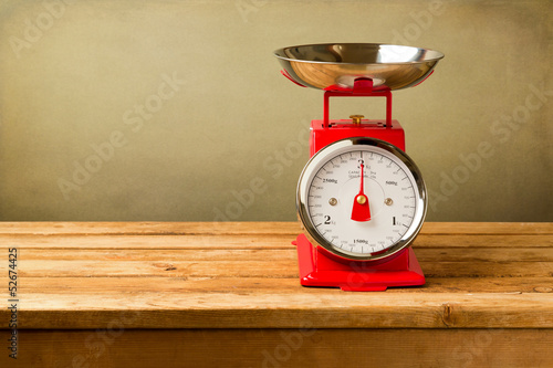 Retro style scales on wooden table over grunge background