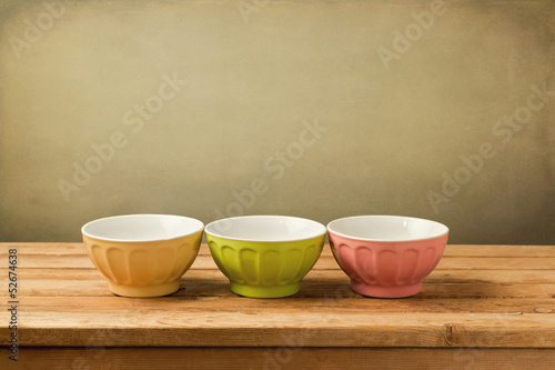 Background with empty colorful bowls on vintage deck table