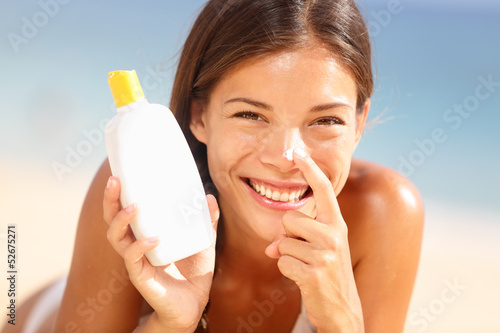 Suntan lotion woman applying sunscreen solar cream