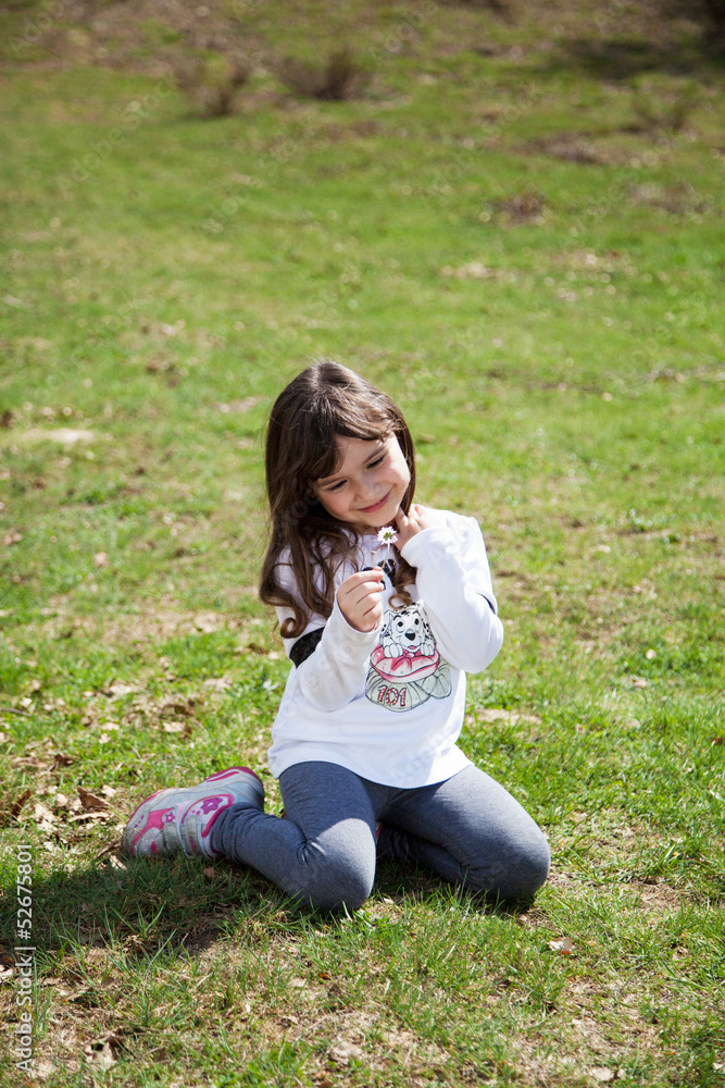Fototapeta premium Dolce bambina seduta nel prato