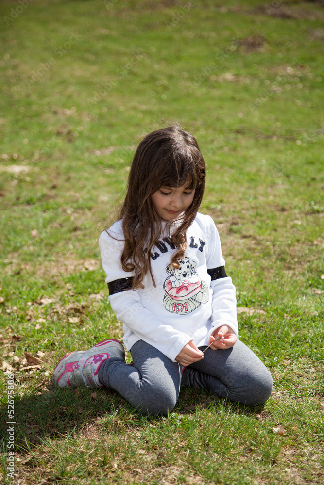 Fototapeta premium Dolce bambina seduta nel prato