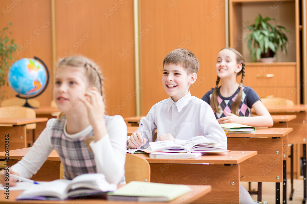 school children at lesson in classroom school children at lesson in classroom