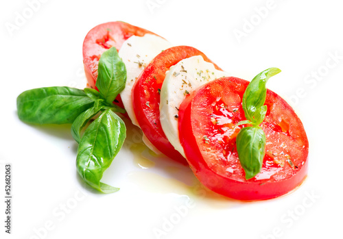 Caprese Salad. Tomato and Mozzarella slices with basil leaves photo