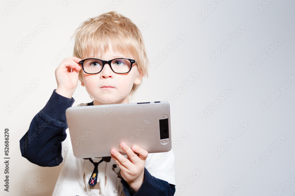 Little boy reading on tablet pc