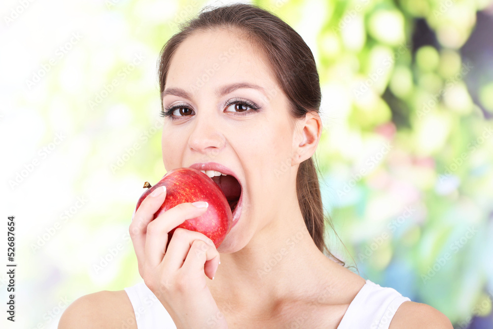 Young woman with apple on bright background Young woman with apple on bright background