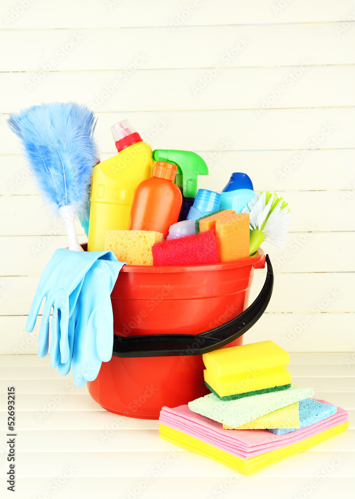 Cleaning items in bucket on white wooden background Cleaning items in bucket on white wooden background