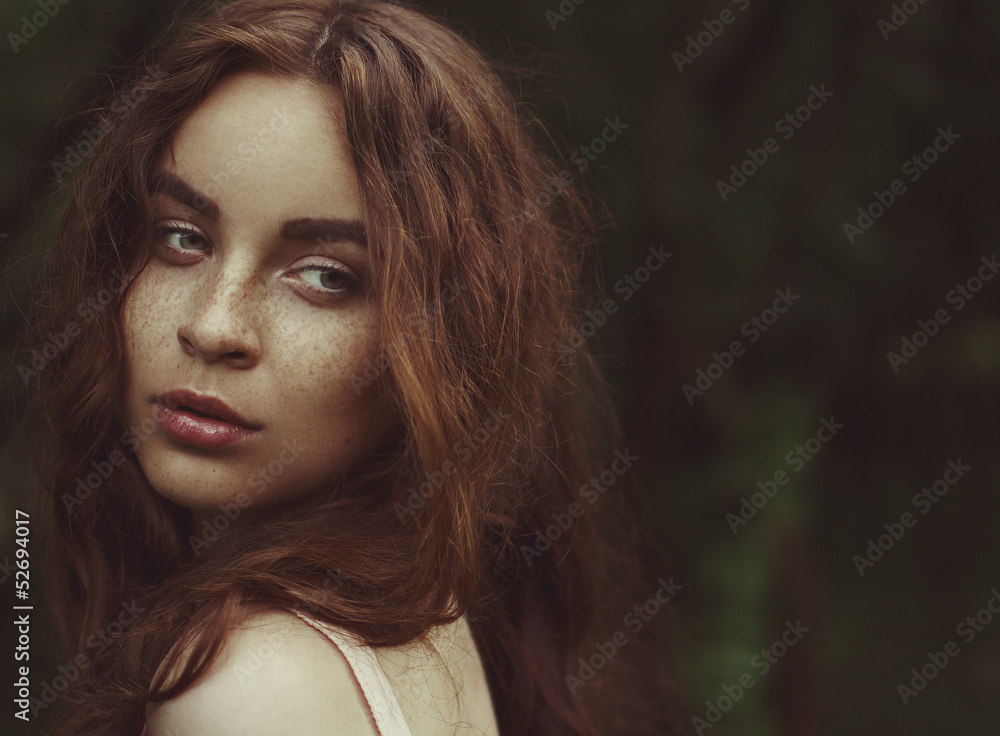Young woman with red hair outdoors portrait. Young woman with red hair outdoors portrait.