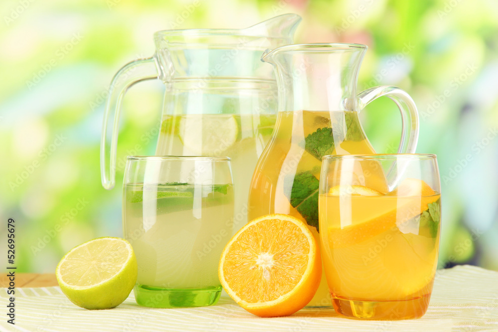 Orange and lemon lemonade in pitchers and glasses Orange and lemon lemonade in pitchers and glasses