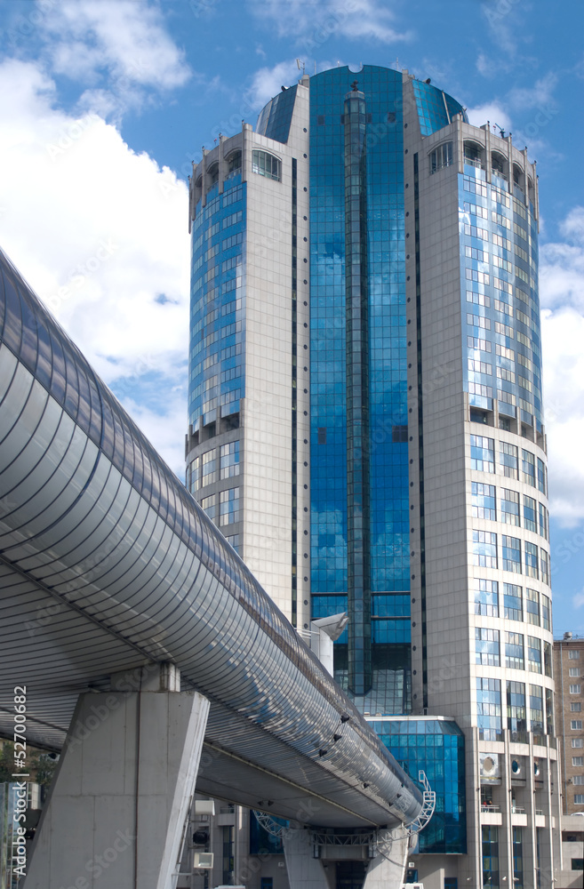 Obraz premium Bottom up view of city high office building and covered bridge