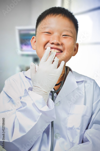 Asian boy dresses up and plays a doctor