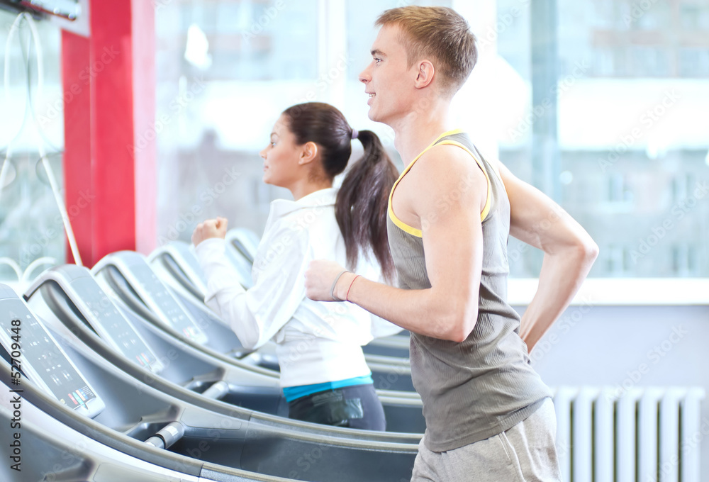 Fototapeta premium Woman and man at the gym exercising