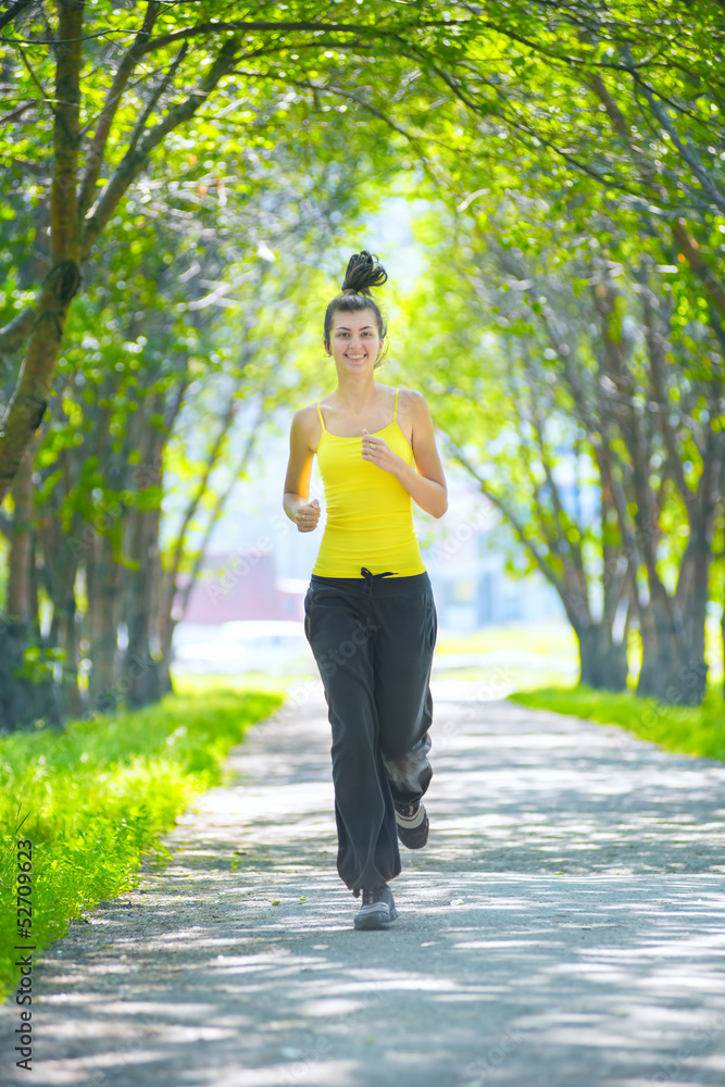 Runner - woman running outdoors in green park Runner - woman running outdoors in green park