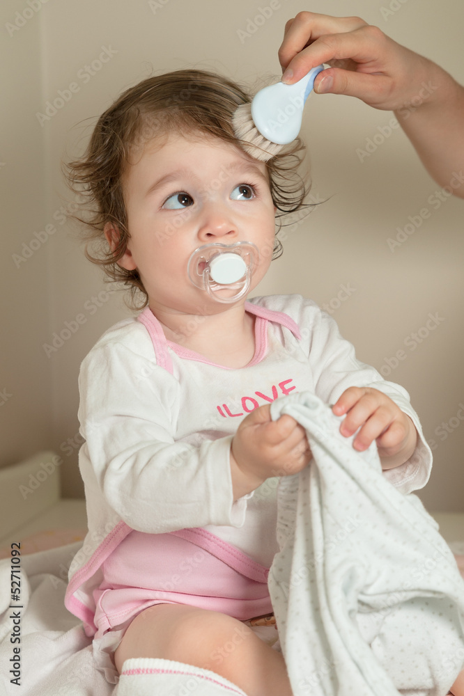 Mother combing her baby girl's hair with hairbrush after shower Stock Photo  | Adobe Stock