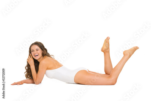 Happy young woman in swimsuit laying on floor