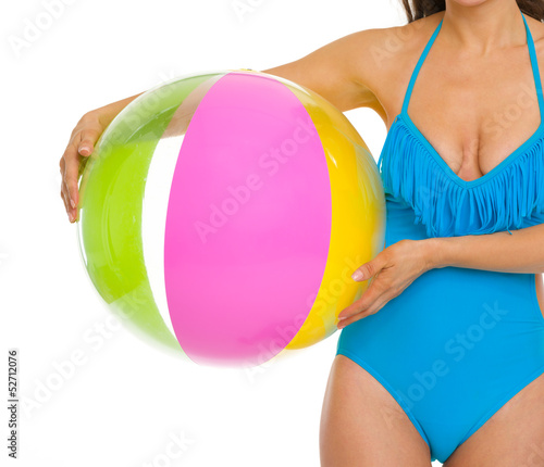 Closeup on young woman in swimsuit holding beach ball