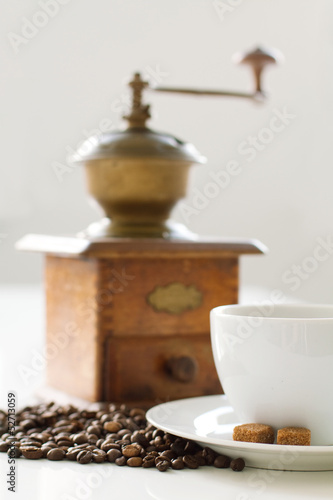 Cup of coffee with sugar and grinder