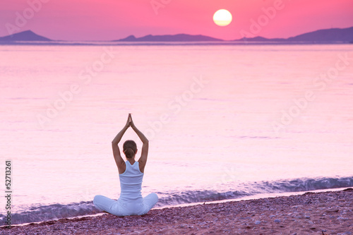 Caucasian woman practicing yoga at seashore