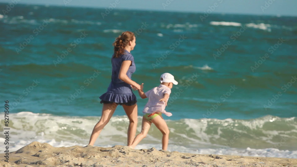 mother and son running together on the beach mother and son running together on the beach