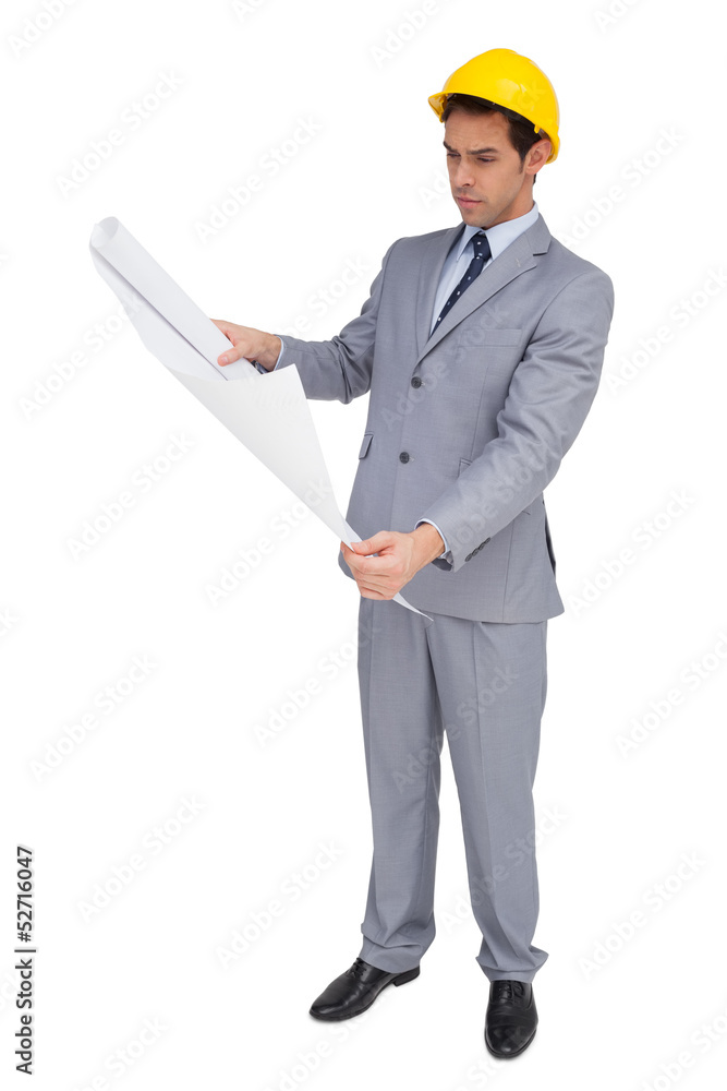 Serious architect with hard hat looking at plans Serious architect with hard hat looking at plans