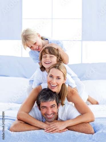 Family piled on top of dad © WavebreakmediaMicro