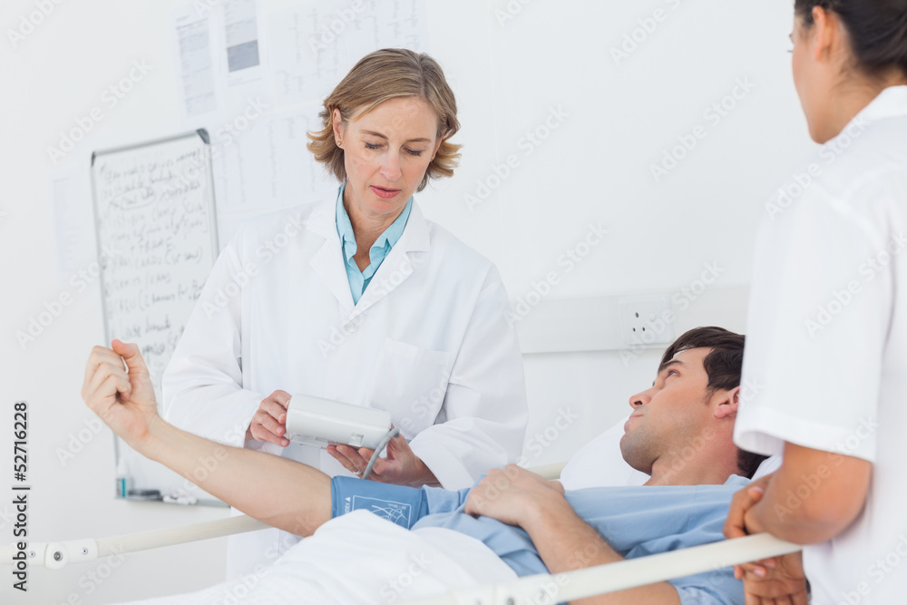Doctor taking the blood pressure of male patient Doctor taking the blood pressure of male patient