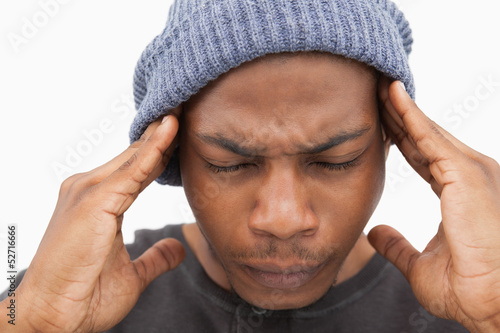Valokuva Man in beanie hat grimacing with pain of headache