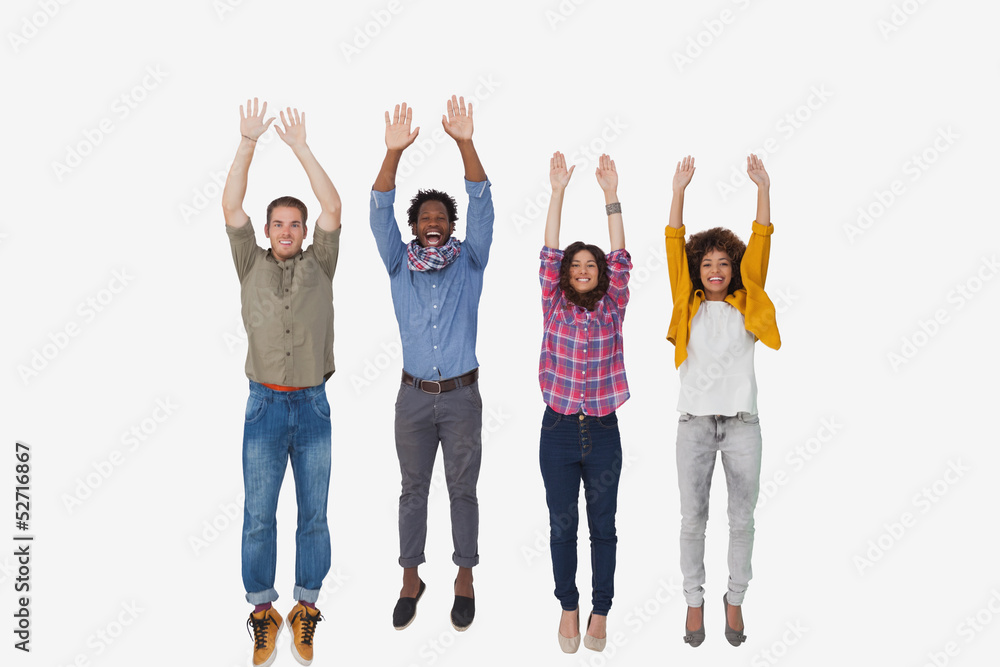 Obraz premium Four stylish friends smiling at the camera and jumping
