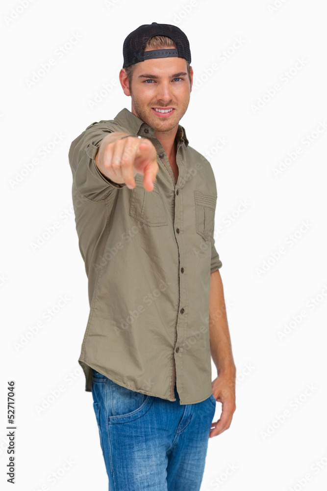 Man smiling and wearing baseball hat backwards and pointing Man smiling and wearing baseball hat backwards and pointing